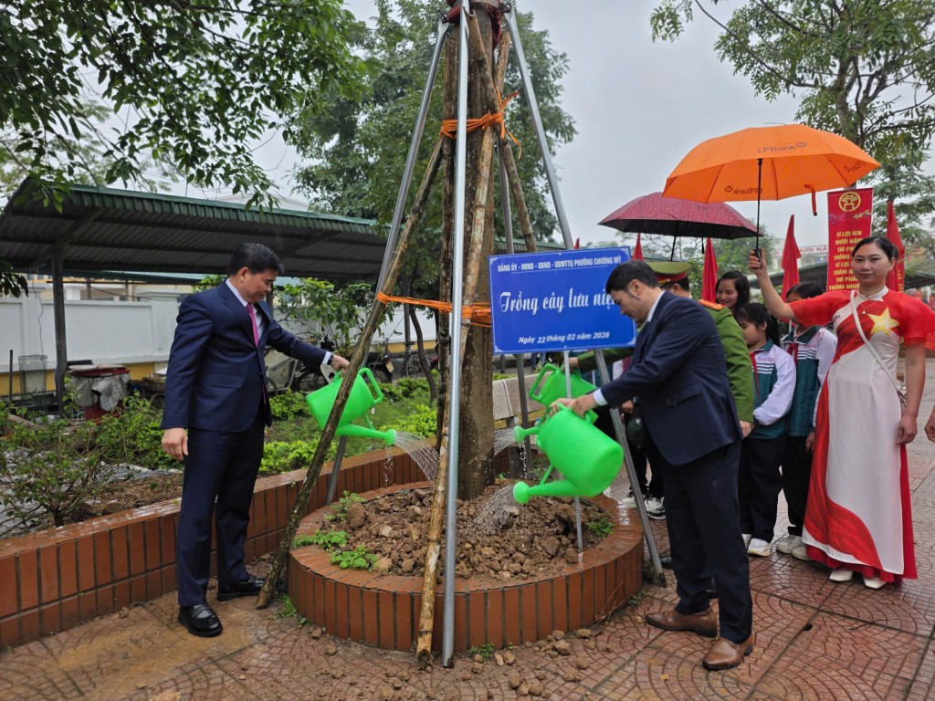 Đồng chí Trịnh Duy Oai (bên trái) và các đồng lãnh đạo phường chăm sóc cây trồng