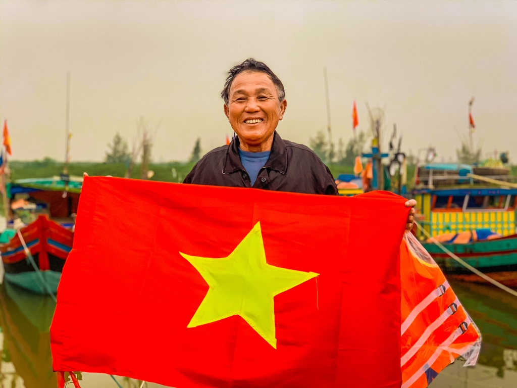 Nụ cười rạng rỡ của ngư dân tại cảng cá Lộc Hà, tỉnh Hà Tĩnh khi nhận món quà là những lá cờ Tổ quốc