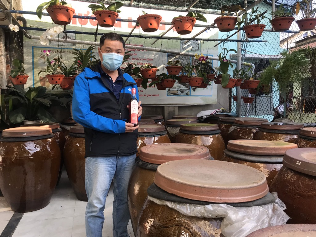 Anh Bùi Thanh Phú bên sản phẩm nước mắm mang “hồn cốt” của làng nghề làm mắm truyền thống Nam Ô