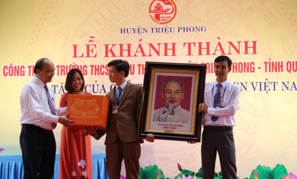 Chủ tịch nước Nguyễn Xuân Phúc trao quà lưu niệm cho Trường THCS Triệu Thành. Ảnh: Đ.T