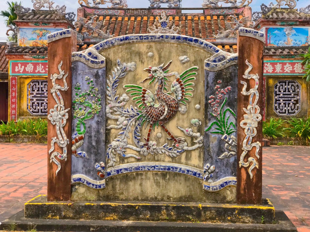Hình ảnh phượng hoàng trên bức bình phong trước nhà thờ tiền hiền của ngũ tộc Đặng, Lâm, Nguyễn, Trần, Lê được đắp nổi hết sức tinh xảo (Ảnh Đ.Minh)