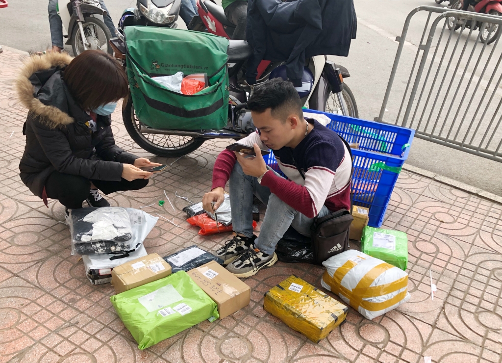 Việc các shipper (người giao hàng) ngồi soạn hàng trên vỉa hè các tòa nhà dần trở nên quen thuộc