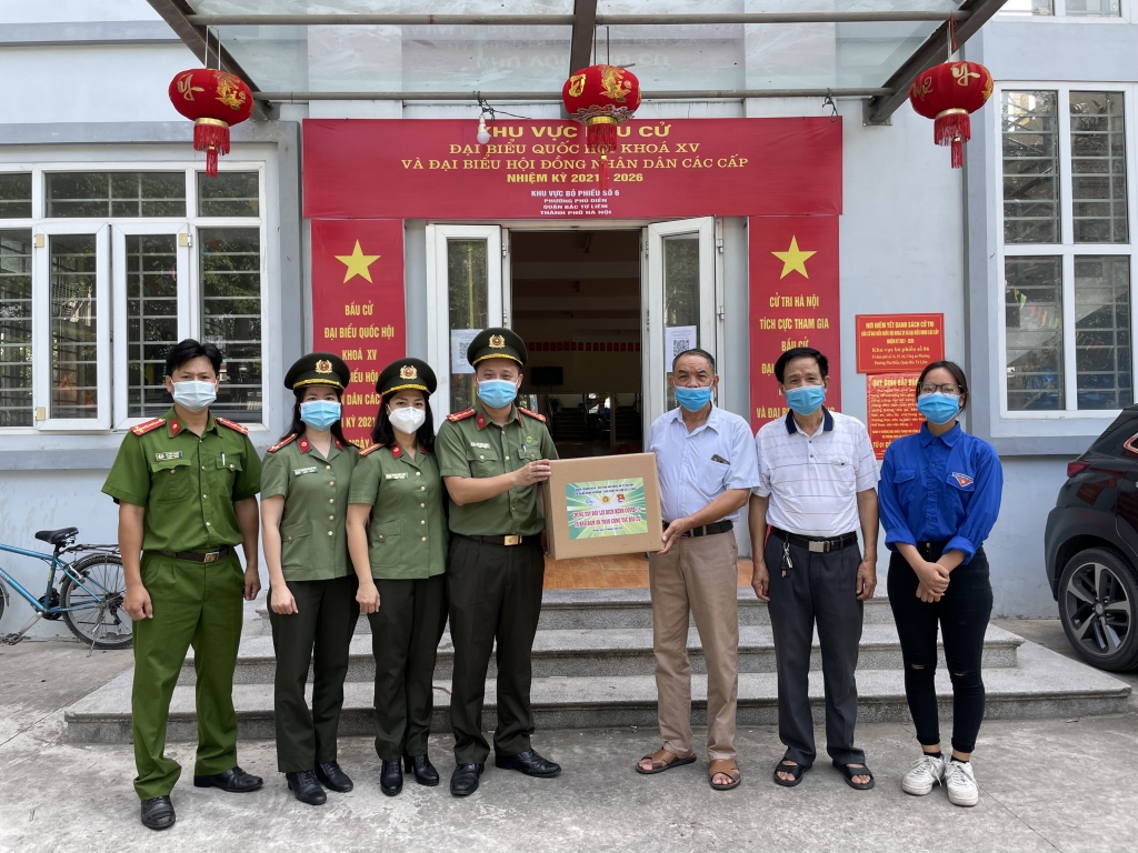 Đồng chí Bùi Mạnh Hùng, Bí thư Đoàn Thanh niên Công an thành phố Hà Nội trao tặng quà tại điểm bầu cử phường Phú Diễn, quận Bắc Từ Liêm