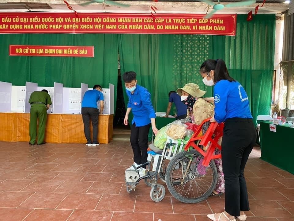 Đoàn viên thanh niên hỗ trợ người đi lại khó khăn tại điểm bỏ phiếu