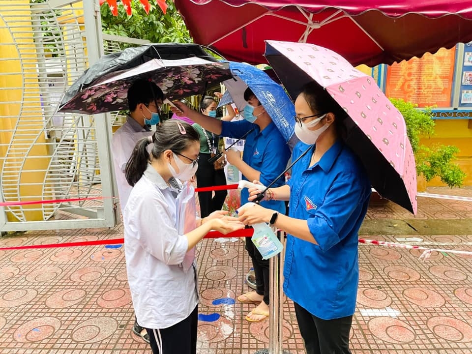 Áo xanh tình nguyện đội mưa hỗ trợ thí sinh tại các điểm thi