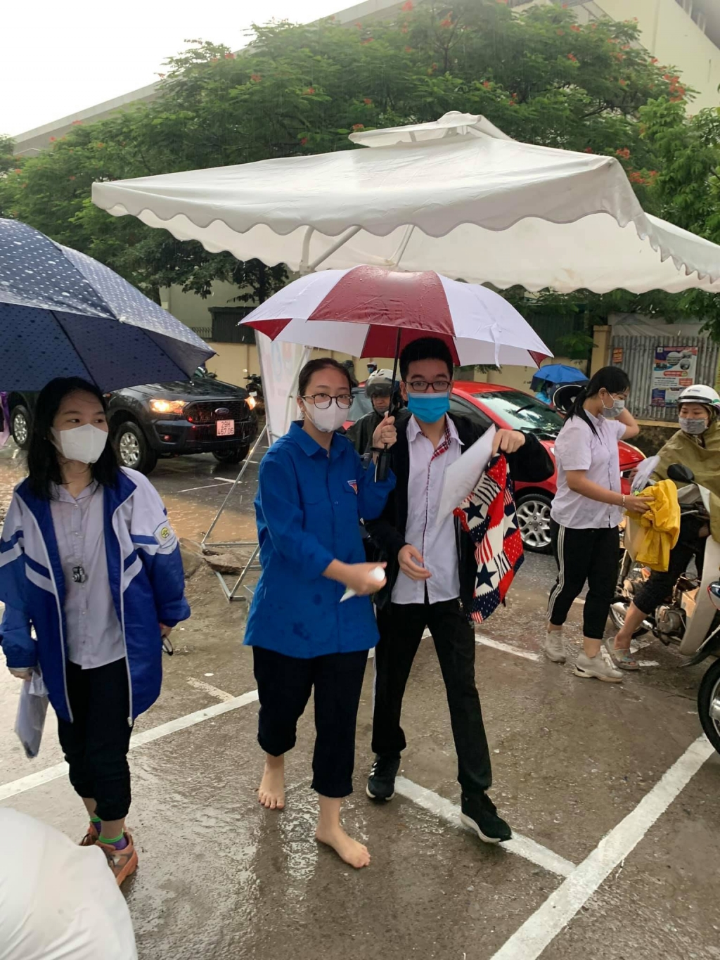 Áo xanh tình nguyện đội mưa hỗ trợ thí sinh tại các điểm thi