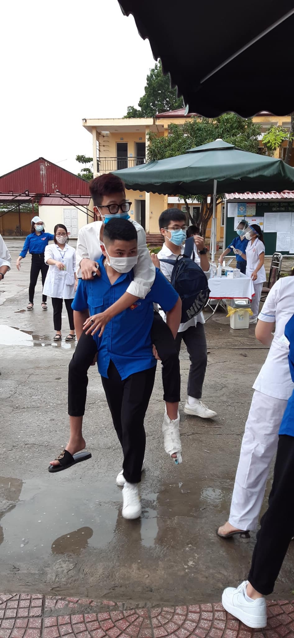 Áo xanh tình nguyện đội mưa hỗ trợ thí sinh tại các điểm thi