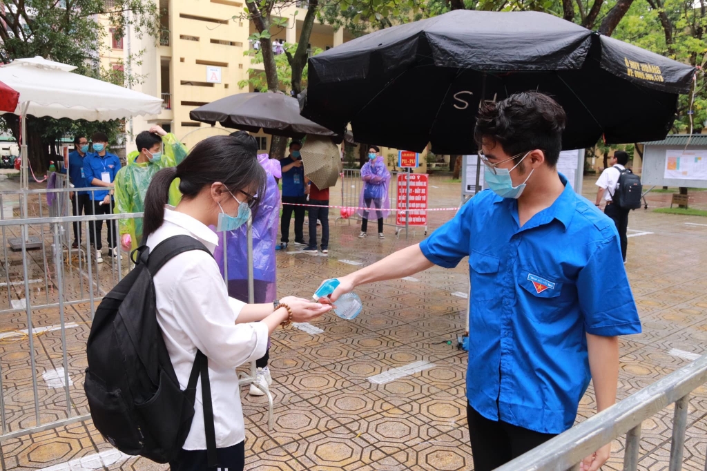 Áo xanh tình nguyện đội mưa hỗ trợ thí sinh tại các điểm thi