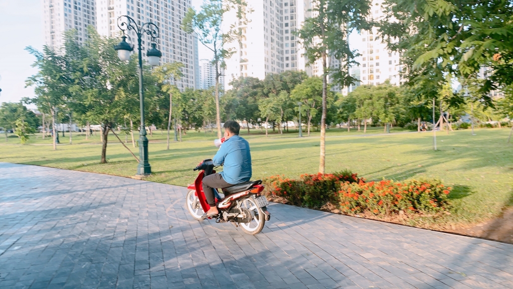 Bảo vệ tại khu vực công viên hồ điều hòa cầm loa đi nhắc nhở người dân ra khỏi khuôn viên để đảm bảo phòng dịch