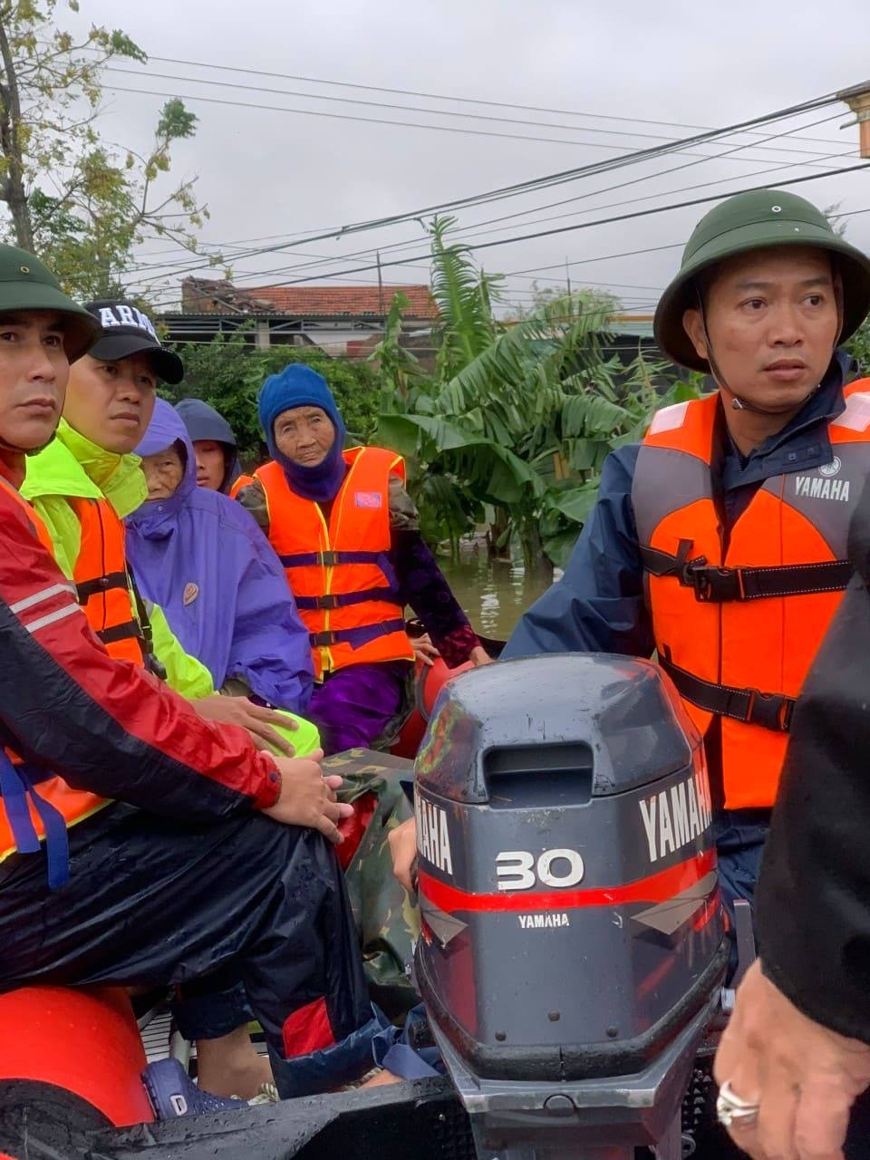 Anh Ngọc (Bên phải) đưa người già ra khỏi nơi nguy hiểm