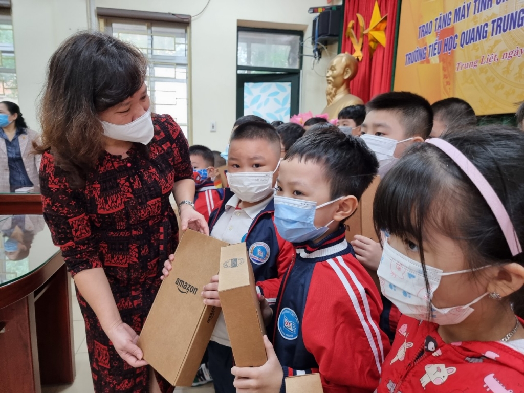 cô Lê Anh Vân, Bí thư Chi bộ, Hiệu trưởng trường Tiểu học Quang Trung trao thiết ị học tập cho học sinh khó khăn