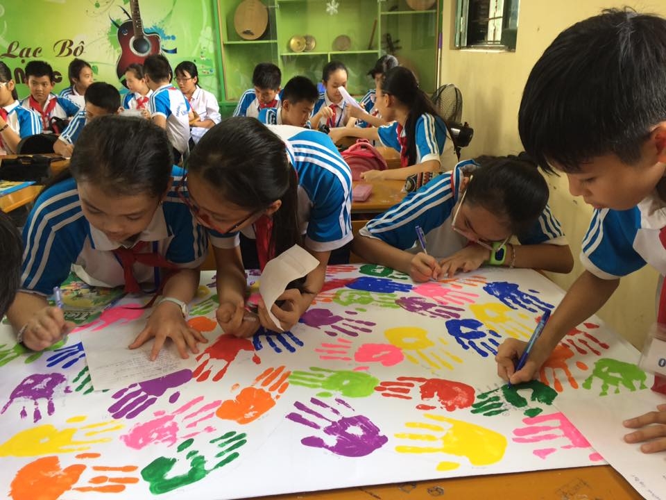 Các em học sinh viết mục tiêu của năm học mới trong bàn tay màu sắc của mình