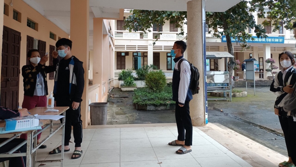 Các thầy cô trường THCS Minh Quang đo thân nhiệt cho học sinh trước khi vào lớp
