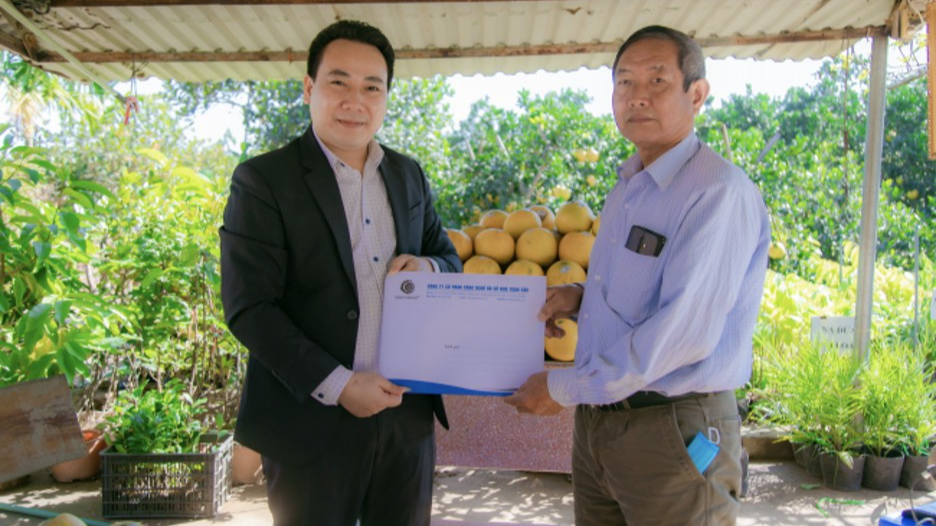Ông Mai Quang Thịnh - Tổng Giám đốc Công ty Cổ phần Công nghệ và Số hóa Toàn cầu trao tặng 10.000 tem truy xuất cho ông Bạch Kim Xuyến - người được giao quản lý, chăm sóc vườn bưởi Diễn