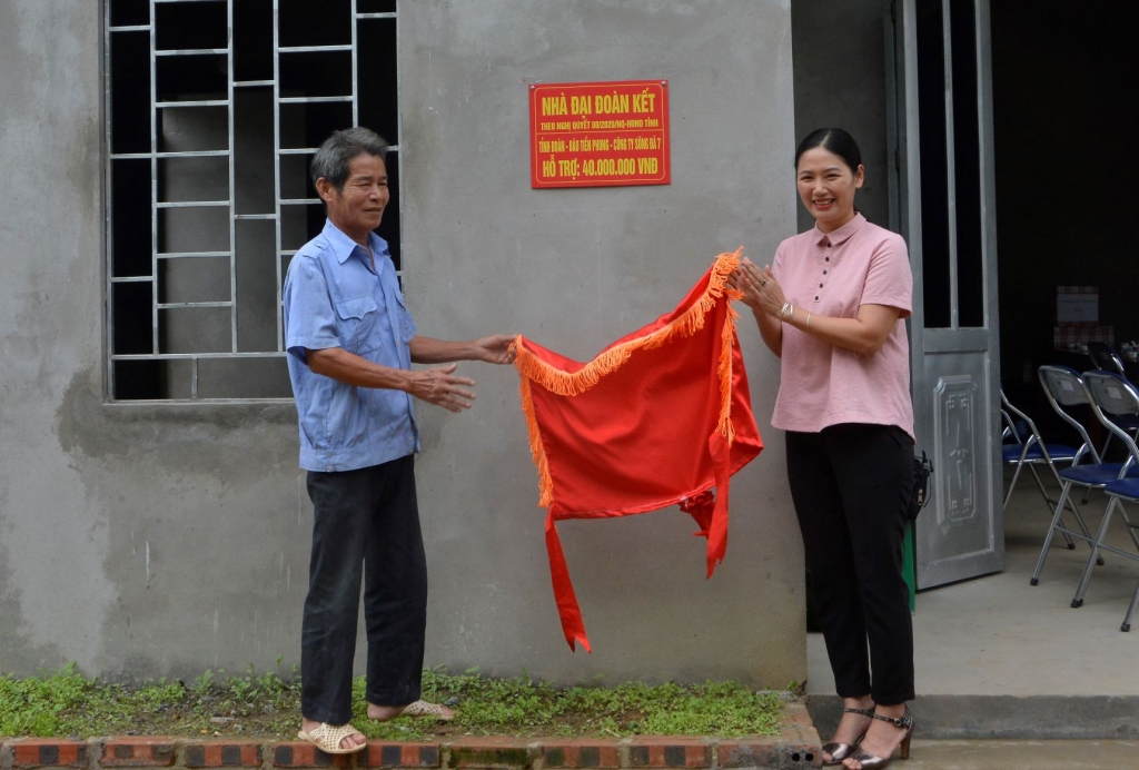 Bí thư Tỉnh đoàn Yên Bái - Đoàn Thị Thanh Tâm và gia đình ông Hoàng Đình Nhân dỡ băng gắn biển nhà đại đoàn kết.