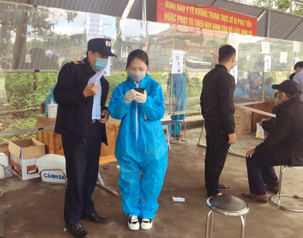 Các thanh niên tình nguyện hướng dẫn người ra vào tỉnh Yên Bái khai báo y tế qua ứng dụng VNEID