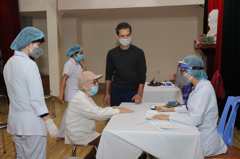 Nhân viên y tế quận Ngô Quyền hỗ trợ hướng dẫn người dân đến tiêm.