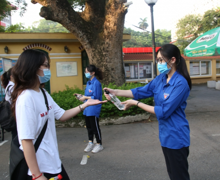 Tình nguyện viên sát khuẩn tay, thực hiện công tác phòng, chống dịch Covid-19 cho thí sinh