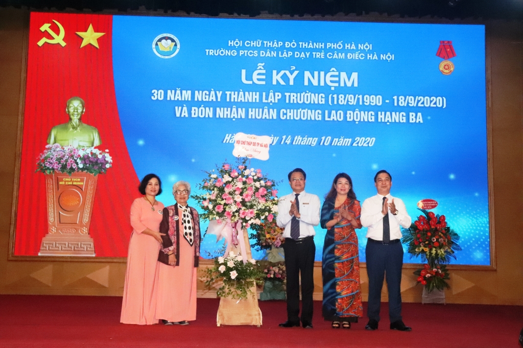 Ông Đào Ngọc Triệu, Chủ tịch Hội Chữ thập đỏ thành phố Hà Nội tặng hoa chúc mừng nhà trường