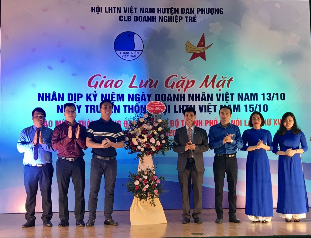 Đồng chí Nguyễn Đức Tiến và đồng chí Trần Quang Hưng tặng hoa chúc mừng doanh nhân trẻ huyện Đan Phượng