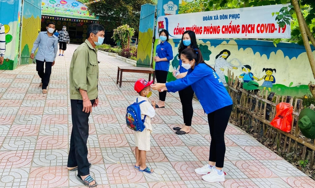 Chị Thuỷ và đoàn viên, thanh niên đo thân nhiệt, cho em nhỏ trong công tác phòng, chống dịch