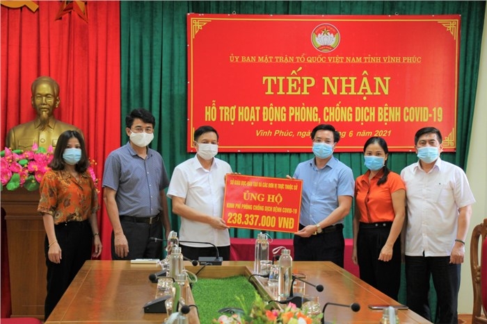 Ông Nguyễn Xuân Viễn - Phó Chủ tịch Ủy ban Mặt trận Tổ quốc tỉnh (áo trắng, góc trái) tiếp nhận kinh phí hỗ trợ của ngành Giáo dục Vĩnh Phúc