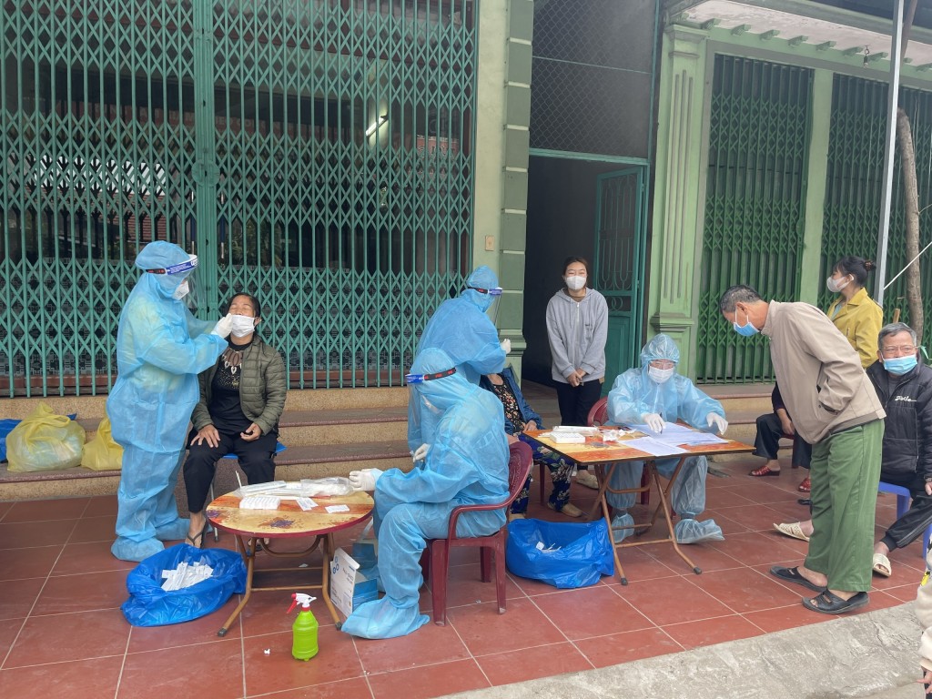 Nhân viên y tế lấy mẫu xét nghiệm Covid-19 cho người dân thị trấn Thổ Tang