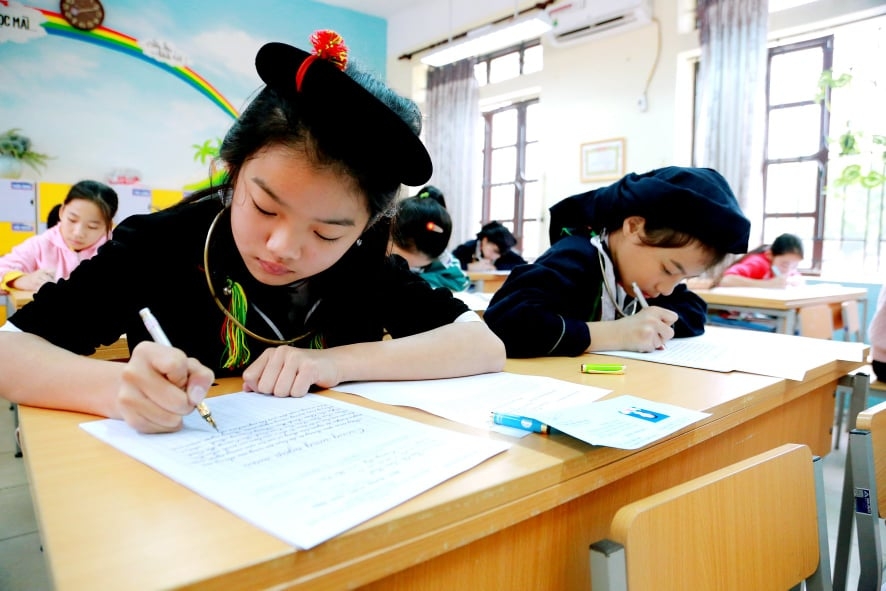 Các học sinh dân tộc thiểu số (DTTS) tham dự phần thi viết chữ đẹp