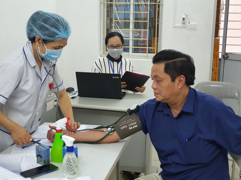 Kiểm tra huyết áp cho người được tiêm chủng trước khi tiêm tại TTYT huyện Mê Linh