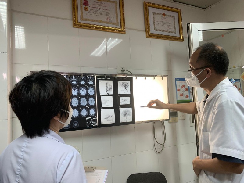 PGS.TS Nguyễn Hồng Hà đang đánh giá phim chụp não và mắt của bệnh nhân.
