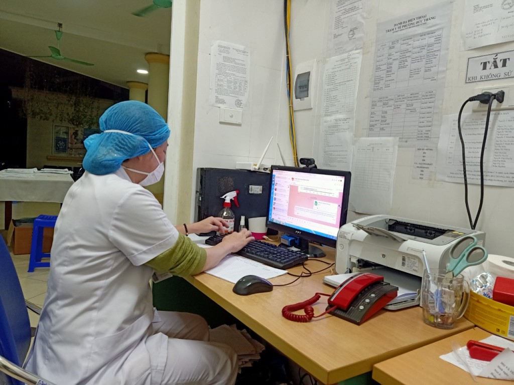 Nhân viên y tế phường Đức Thắng (quận Bắc Từ Liêm) tư vấn, hỗ trợ online cho các F0 điều trị tại nhà qua nhóm Zalo