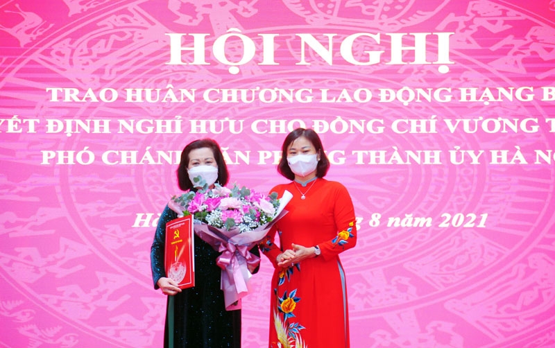 Phó Bí thư Thường trực Thành ủy Hà Nội Nguyễn Thị Tuyến trao quyết định và tặng hoa chúc mừng đồng chí Vương Thị Thanh Hương