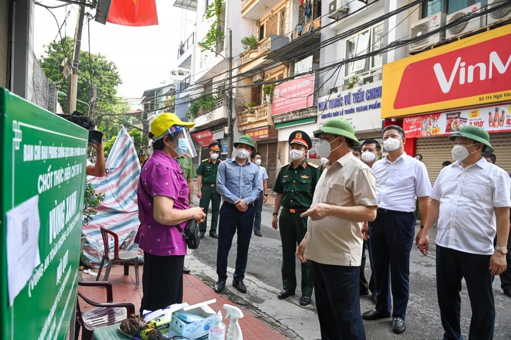 Bí thư Thành ủy Đinh Tiến Dũng và các đồng chí lãnh đạo TP, quận Đống Đa trò chuyện, động viên lực lượng làm hiệm vụ tại chốt kiểm soát