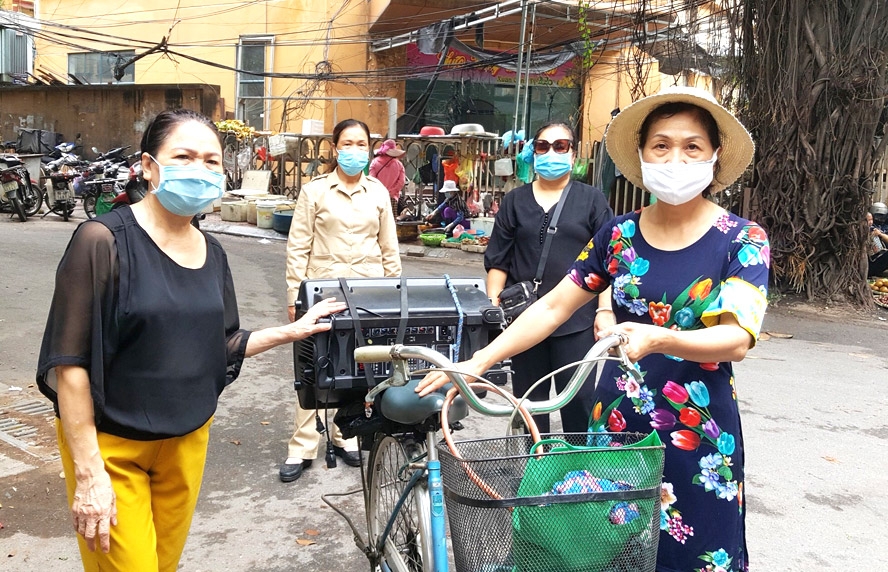 Bà Nguyễn Thị Thanh Bình (bên phải) cùng cán bộ Chi hội phụ nữ số 4 phường Láng Thượng (quận Đống Đa) sử dụng loa lưu động tuyên truyền công tác phòng, chống dịch Covid-19