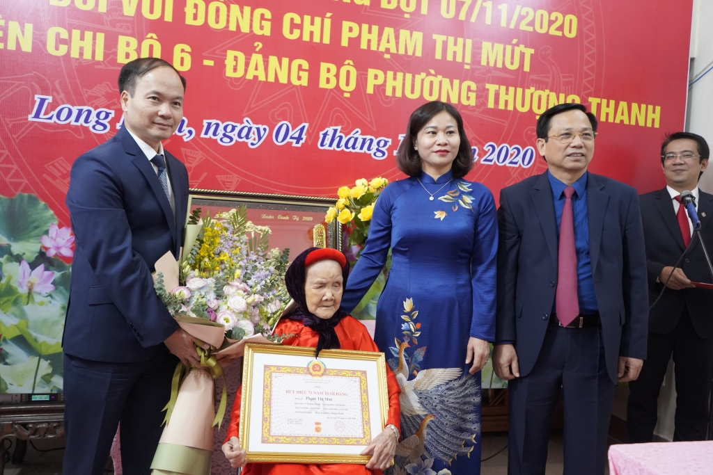 Phó Bí thư Thường trực Thành ủy Nguyễn Thị Tuyến trao Huy hiệu Đảng cho đảng viên lão thành Phạm Thị Mứt