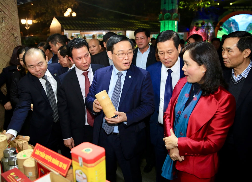 Bí thư Thành ủy Hà Nội Vương Đình Huệ với các đại biểu tham quan gian trưng bày sản phẩm đặc sản của tỉnh Hà Giang tại sự kiện