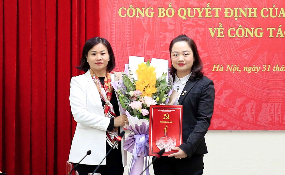 Phó Bí thư Thường trực Thành ủy Hà Nội Nguyễn Thị Tuyến trao quyết định của Ban Thường vụ Thành ủy và tặng hoa chúc mừng đồng chí Bùi Thị Thu Hiền