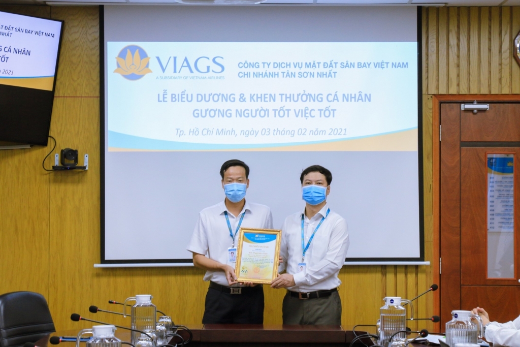 Anh Phạm Hữu Tuân (bên trái) nhận thư khen của ban lãnh đạo VIAGS tại Tân Sơn Nhất vì hành động ý nghĩa