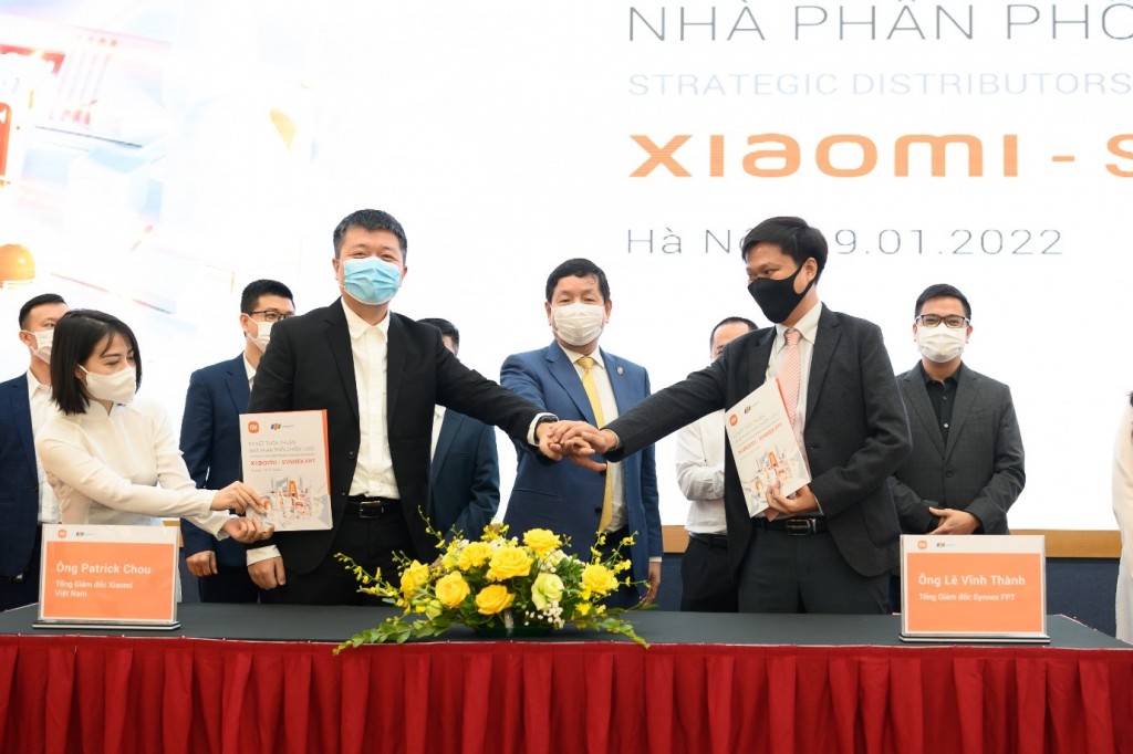 Ông Patrick Chou (TGĐ Xiaomi Việt Nam) và ông Lê Vĩnh Thành (TGĐ Synnex FPT) đại diện ký kết, dưới sự chứng kiến của ông Trương Gia Bình (Chủ tịch Tập đoàn FPT)