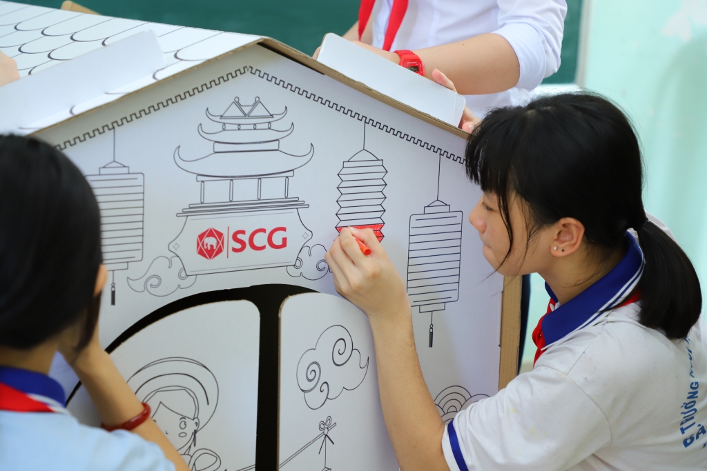 Các em học sinh khám phá ngôi nhà giấy Doozypack Paper Playhouse làm từ bìa cạc tông tái chế   một sản phẩm của SCG Bao bì do Tập đoàn SCG trao tặng