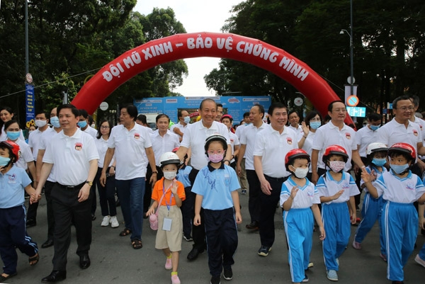 Các đại biểu và và các em học sinh tại sự kiện đi bộ vận động toàn dân đội mũ bảo hiểm cho trẻ em