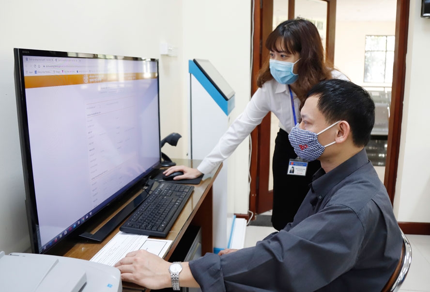 Cán bộ hỗ trợ người dân thực hiện dịch vụ công trực tuyến tại bộ phận “một cửa” quận Hai Bà Trưng, Hà Nội