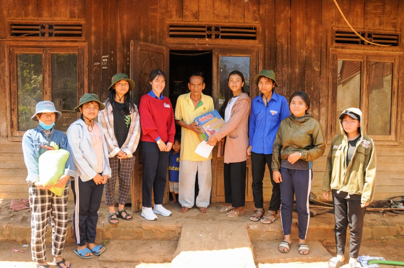 Nhi (mặc áo đỏ) cùng các bạn trong nhóm đến thăm một gia đình có hoàn cảnh khó khăn tại huyện Di Linh