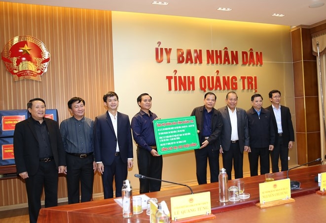 Bộ trưởng Bộ Nông nghiệp và Phát triển nông thôn Nguyễn Xuân Cường trao quà ủng hộ cho tỉnh Quảng Trị. - Ảnh: VGP/Lê Sơn