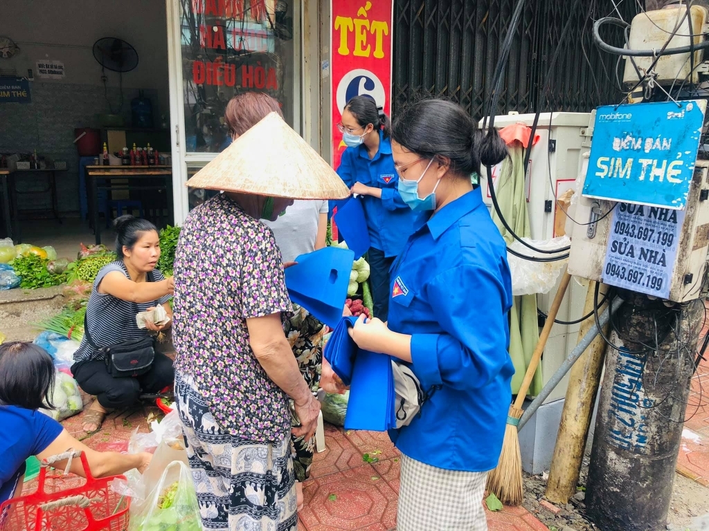 Đoàn viên thanh niên quận Ba Đình (Hà Nội) hướng dẫn người dân dung túi thân thiện với môi trường thay túi nilon