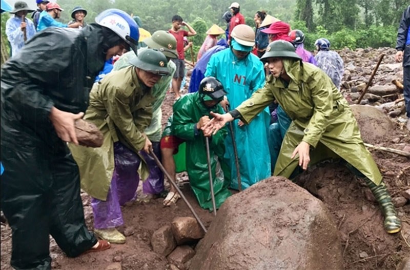 Bộ đội Biên phòng tỉnh Quảng Trị giúp dân xã A Ngo, huyện Đakrông, Quảng Trị dọn đoạn đường bị đất đá vùi lấp sau lũ dữ 