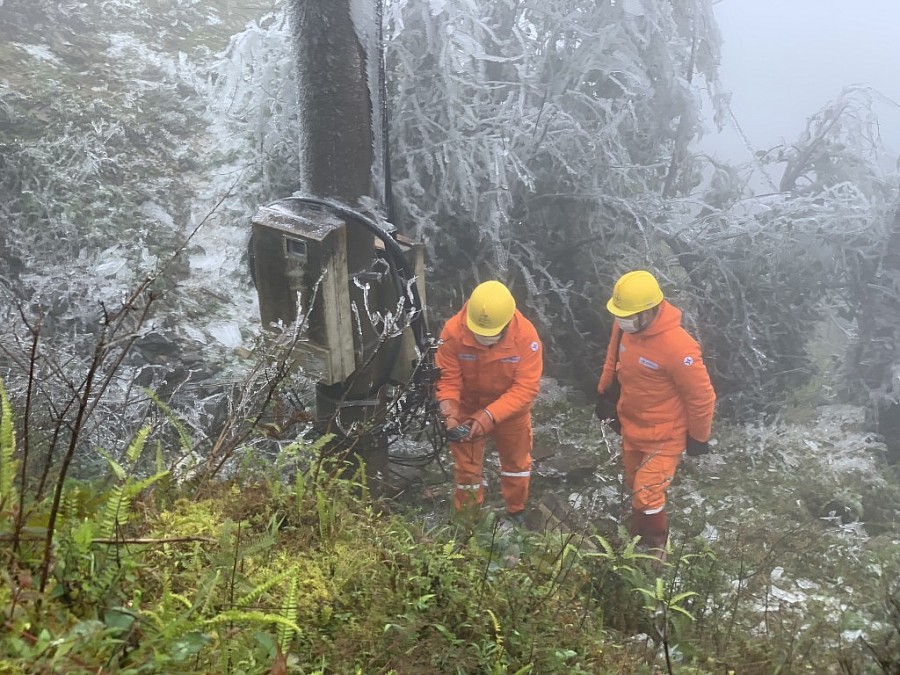 Công nhân Điện lực Lộc Bình (PC Lạng Sơn) kiểm tra tình trạng vận hành lưới điện trên đỉnh Mẫu Sơn trong điều kiện băng tuyết bao phủ