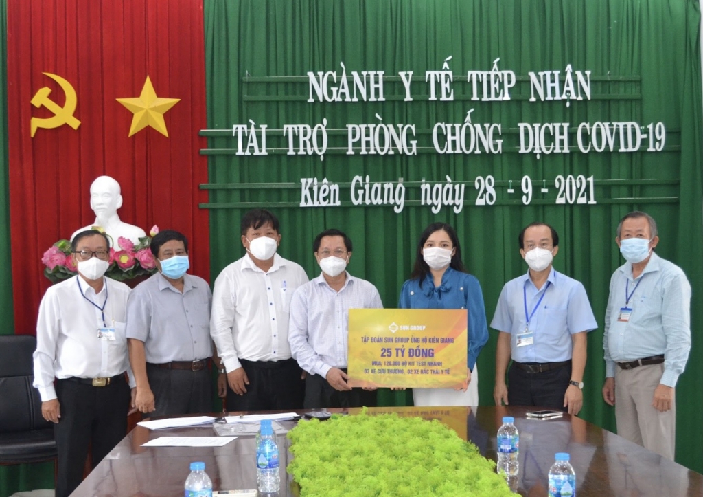 Đại diện Tập đoàn Sun Group (áo xanh) trao bảng tượng trưng hỗ trợ lãnh đạo Sở Y tế Kiên Giang