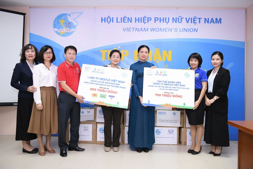 Chủ tịch Hội LHPN Việt Nam Hà Thị Nga (áo dài xanh), Phó Chủ tịch Hội Trần Thị Hương (kế bên trái), tiếp nhận phần hỗ trợ từ đại diện công ty Nestlé Việt Nam