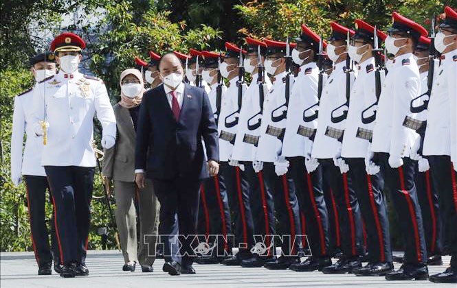 Chủ tịch nước Nguyễn Xuân Phúc và Tổng thống Cộng hòa Singapore Halimah Yacob duyệt đội danh dự. Ảnh: Thống Nhất/TTXVN